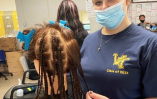Hairdressing student works on braiding hair.