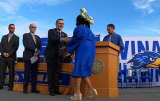 Student shakes hand with Dr. Rivera on graduation stage.